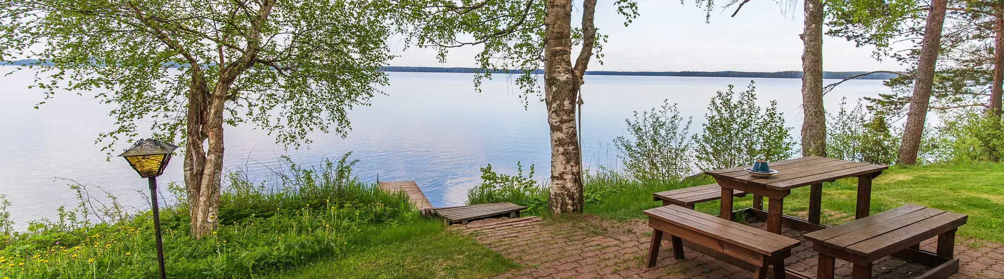 Rantanurmikko ja pöytä järven äärellä